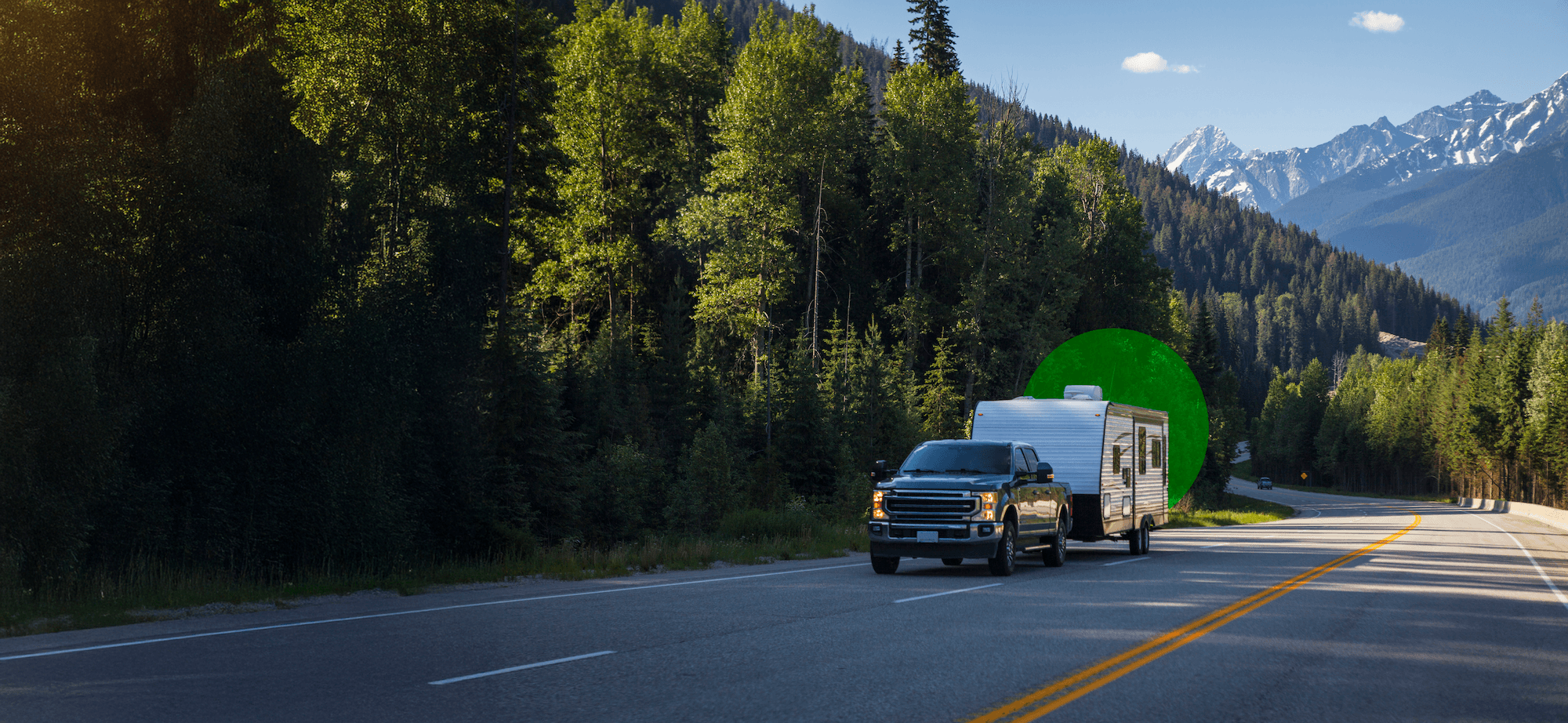 RV parked by serene lake with mountains in background at sunset